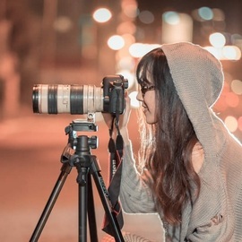 Une photographe en train de prendre une photo avec son appareil photo installé sur trépied